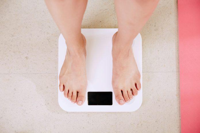 Photo of two feet standing on a white scale