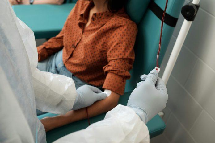 Woman sitting in chair donating blood | Why Blood Donor Month Matters for Our Comunidad: The Importance of Latinos and Latinas Donating Blood