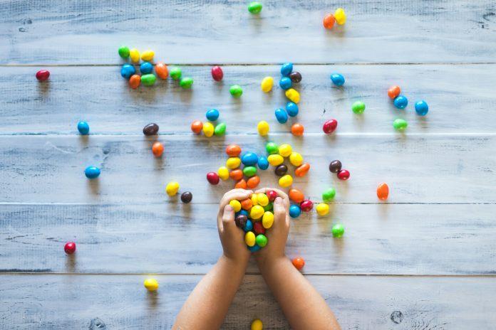 Small child's hands holding m&ms | Afrolatinidad