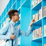 Boy browsing book shelf | Importance of libraries