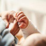 Mom Holding babies hand| The Bittersweet Truth About Watching Your Kids Grow Up