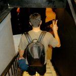 Young man with backpack walking down steps with a peace sign made on his hands | Firstborn: A Latina Mom’s Reflection on Parenting, Growth, and Letting Go
