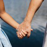 younger girl holding hands with old mom