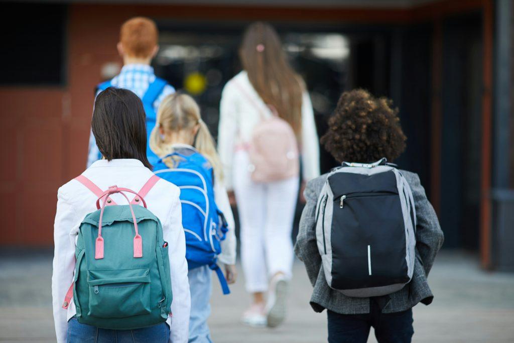 Kids walking into school with backpacks | Back to School Traditions | Latina Mom Collective
