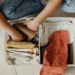 Woman organizing clothes in bin | Capsule wardrobe for kids