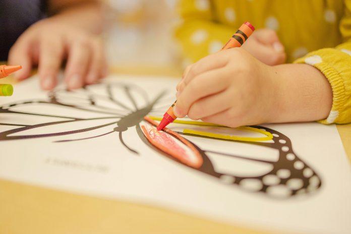 little girl coloring a butterfly coloring sheet | first day of preschool mom